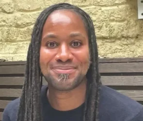 Le professeur Jason Arday souriant, célébrant sa nomination historique à l'Université de Cambridge.