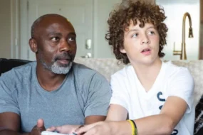 Peter Mutabazi souriant tendrement aux côtés de son fils adoptif Tony, après lui avoir offert un foyer aimant et définitif.