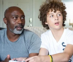 Peter Mutabazi souriant tendrement aux côtés de son fils adoptif Tony, après lui avoir offert un foyer aimant et définitif.