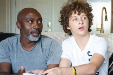 Peter Mutabazi souriant tendrement aux côtés de son fils adoptif Tony, après lui avoir offert un foyer aimant et définitif.