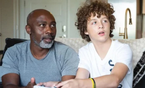 Peter Mutabazi souriant tendrement aux côtés de son fils adoptif Tony, après lui avoir offert un foyer aimant et définitif.