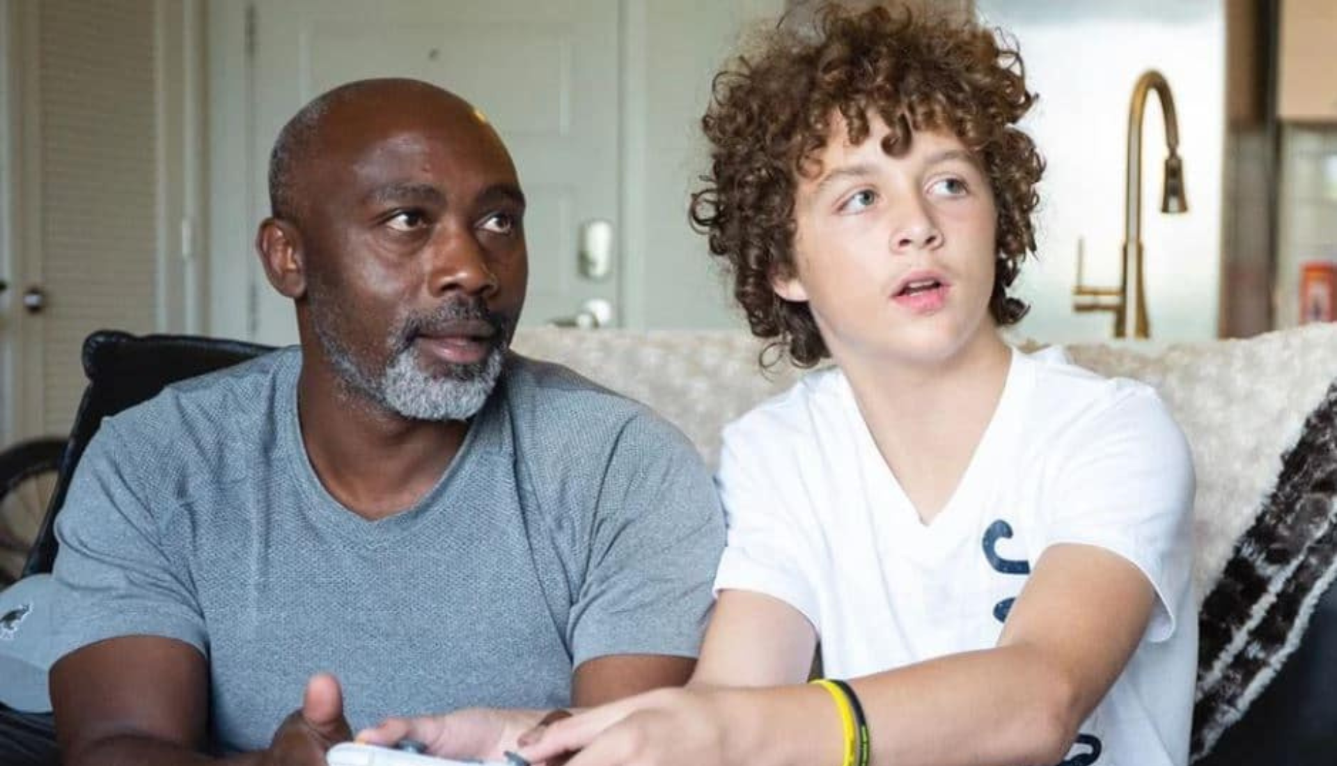 Peter Mutabazi souriant tendrement aux côtés de son fils adoptif Tony, après lui avoir offert un foyer aimant et définitif.